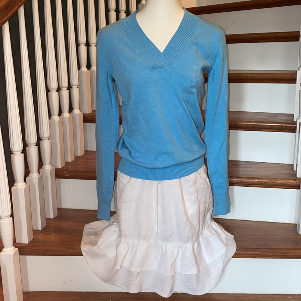 This white linen skirt has a tiered slightly ruffled  hem with adjustable waist.